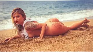 Loira tatuada chupa o pau dele em uma praia pública... Areia por todo o peito dela.